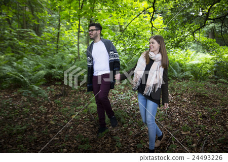 Relaxed couple hugging while walking outdoors. 24493226