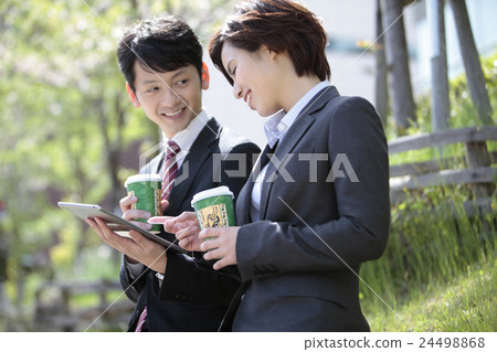 Businessperson and business woman watching tablet PC Businessperson and business woman watching tablet PC 24498868