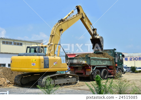 A hydraulic excavator loading surplus soil into a dump 24515085