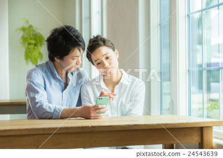 A couple looking at a smartphone 24543639