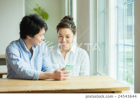 A couple looking at a smartphone A couple looking at a smartphone 24543644