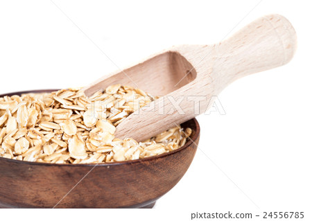 Wooden bowl with oats flakes pile on white Wooden bowl with oats flakes pile on white 24556785