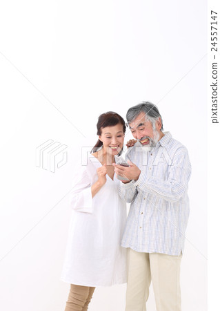 A couple looking at smartphones A couple looking at smartphones 24557147