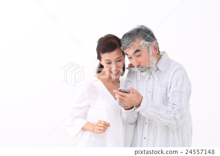 A couple looking at smartphones A couple looking at smartphones 24557148