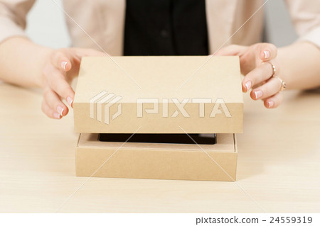 Woman opening box with new parcel, close-up 24559319