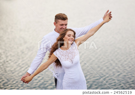 beautiful young couple walking near the lake on beautiful young couple walking near the lake on 24562519