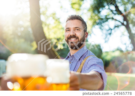Man in traditional bavarian clothes holding mug of Man in traditional bavarian clothes holding mug of 24565778
