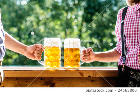 Men in traditional bavarian clothes holding mugs Men in traditional bavarian clothes holding mugs 24565800