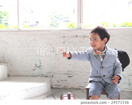 坐與一個巧妙的指向的手指的男孩 坐與一個巧妙的指向的手指的男孩 24571556