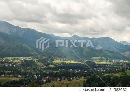 View over green valley, village and mountains View over green valley, village and mountains 24582682