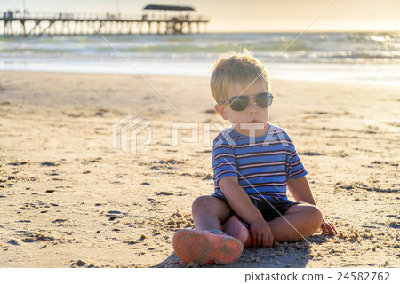 Cute kid sitting on the beach 24582762