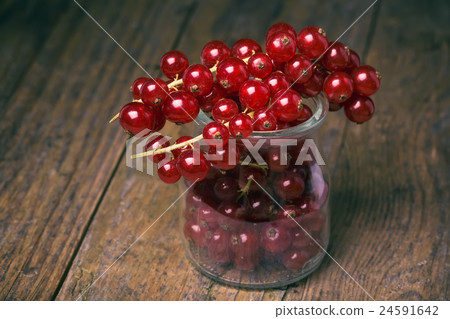 Bunch of red currants in a glass cup. Bunch of red currants in a glass cup. 24591642