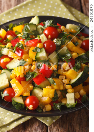 salad of corn, greens, tomatoes, cucumbers 24591979