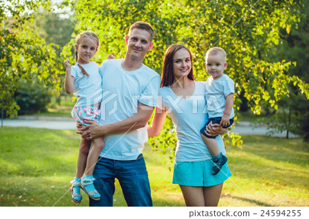 Portrait of young happy family walking in sunny 24594255