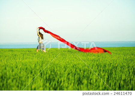 Young happy woman in wheat field with fabric 24611470