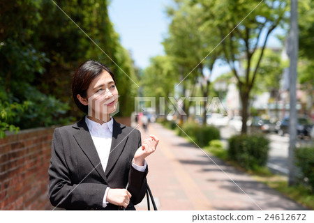 從走在城市的一位年輕辦公室工作者的一名婦女 從走在城市的一位年輕辦公室工作者的一名婦女 24612672