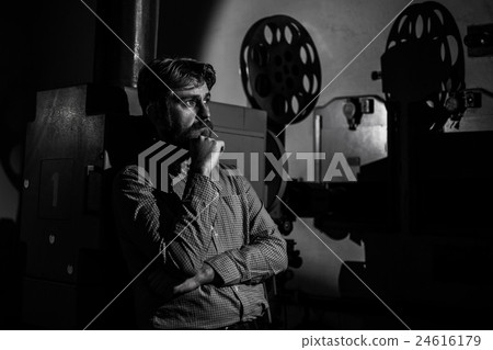 man standing near a film in the room projectionist man standing near a film in the room projectionist 24616179
