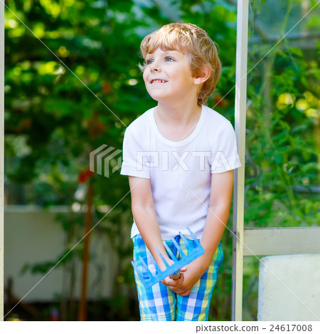 little kid boy working with garden hoe in 24617008