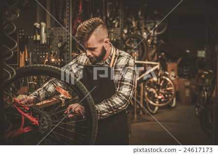 Stock Photo: Bicycle mechanic doing his work in workshop