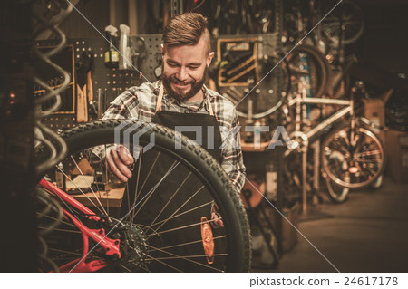 Stock Photo: Bicycle mechanic doing his work in workshop