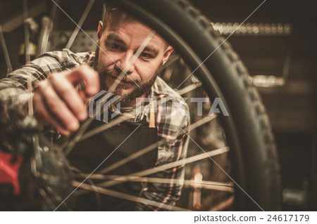 Stock Photo: Bicycle mechanic doing his work in workshop