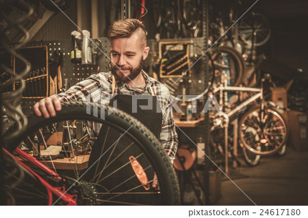 Stock Photo: Bicycle mechanic doing his work in workshop