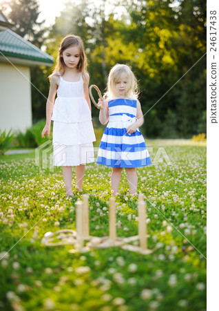 Two cute little sisters playing ring toss game 24617438