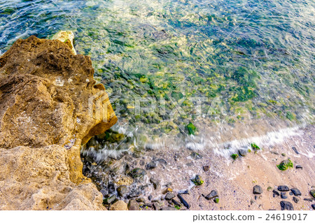 wave rolls onto the rocks of sandy coast wave rolls onto the rocks of sandy coast 24619017