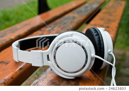 closeup of white headphones on bench in outdoor closeup of white headphones on bench in outdoor 24623803