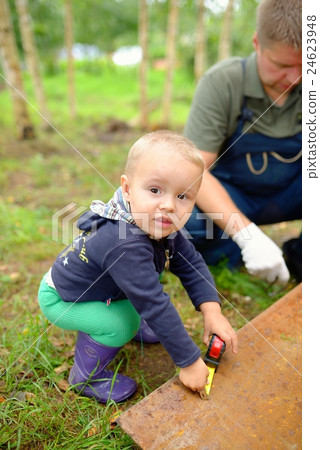 Little son helping his father with building work Little son helping his father with building work 24623948