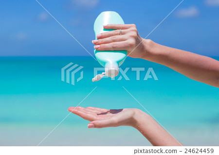 Woman hands putting sunscreen from a suncream 24624459
