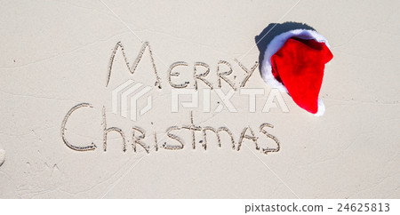 Santa Hat on white sandy beach and Merry Christmas Santa Hat on white sandy beach and Merry Christmas 24625813