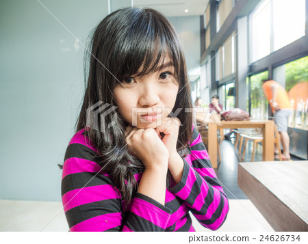 Young smiling asian women sitting in coffee shop Young smiling asian women sitting in coffee shop 24626734