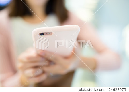 Woman sending sms on mobile phone 24628975