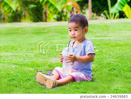 The boy is sucking water with straws in a glass with ice. water 24639865