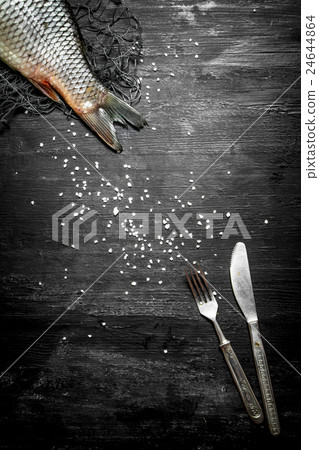 Raw fish with a knife and fork. 24644864