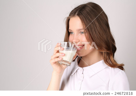 Girl in drinking milk. Close up. White background 24672818