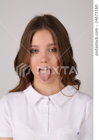 Girl in T-shirt showing her tongue. Close up 24673160