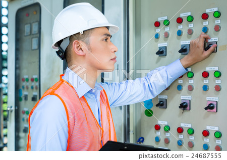 Asian technician at panel on construction site 24687555