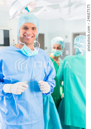 Hospital surgeons operating in operation room Hospital surgeons operating in operation room 24687575