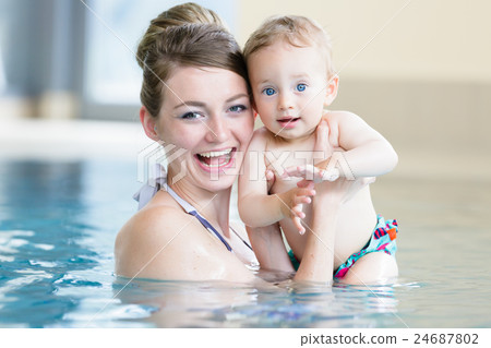Mother and her newborn child at infant swimming  24687802