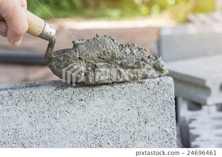 Cement mix with a trowel in a hand on the brick Cement mix with a trowel in a hand on the brick 24696461