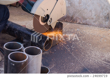 electric saw and hands of worker with sparks. 24699719