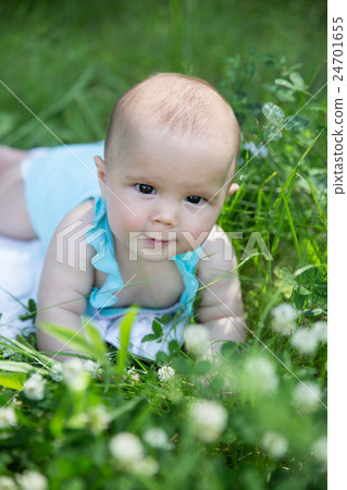 Baby girl crawling on the grass. Selective focus Baby girl crawling on the grass. Selective focus 24701655