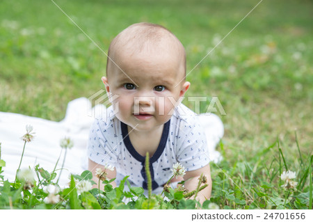 Baby girl crawling on the grass. Selective focus 24701656