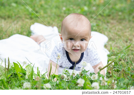 Baby girl crawling on the grass. Selective focus Baby girl crawling on the grass. Selective focus 24701657