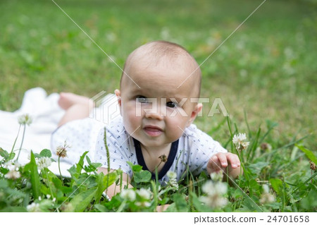 Baby girl crawling on the grass. Selective focus 24701658