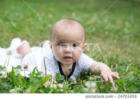 Baby girl crawling on the grass. Selective focus Baby girl crawling on the grass. Selective focus 24701659