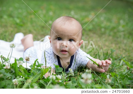 Baby girl crawling on the grass. Selective focus Baby girl crawling on the grass. Selective focus 24701660