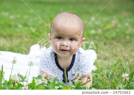 Baby girl crawling on the grass. Selective focus Baby girl crawling on the grass. Selective focus 24701661